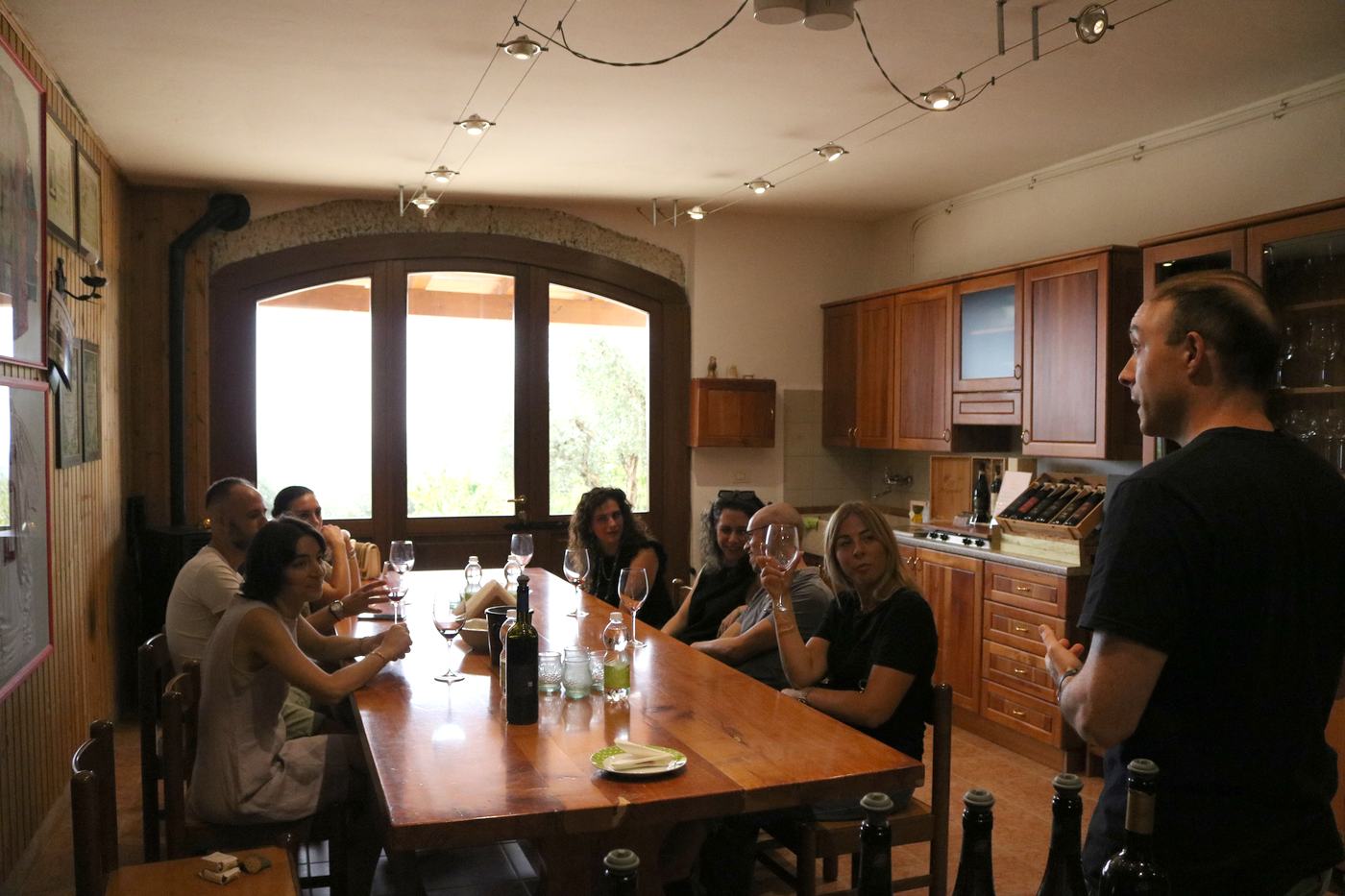 Guests seated around a wooden tasting table
