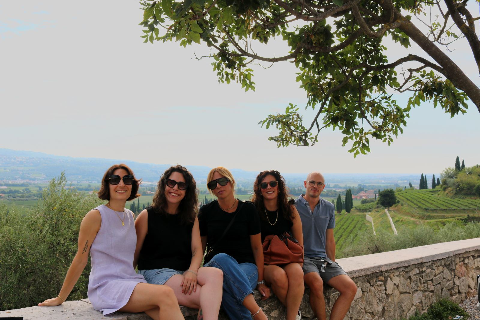 Guests resting on a stone wall above the valley